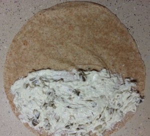 Spread a layer of jalapeno and cream cheese onto a tortilla